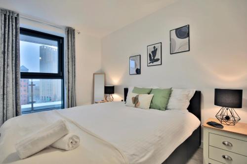 una camera da letto con un grande letto e una finestra di KA Propertiess - 2Bed & 2Baths Ensuite, Parking, Balcony, Wi-Fi, Netflix, Media City a Manchester