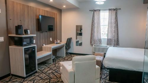 Habitación de hotel con cama y escritorio en SureStay Hotel by Best Western Houston Southeast en Houston