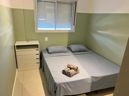 Un dormitorio con una cama con una cámara. en MALIBU RESORT CLUB, en Florianópolis