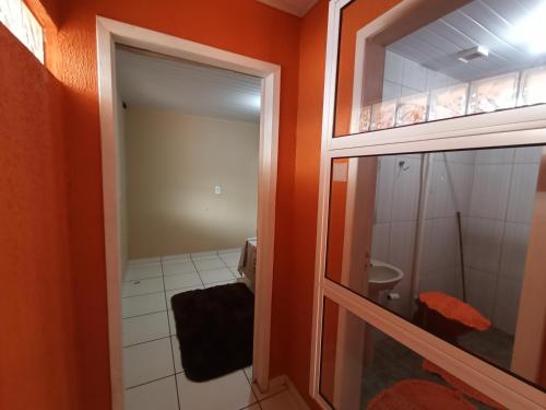 a bathroom with a toilet and a glass door at Casa inteira, Quarto p 3 pessoas com Ar, Sala Cozinha,Wifi,Garagem Coberta in Foz do Iguaçu