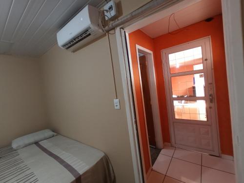 a small room with a bed and a door at Casa inteira, Quarto p 3 pessoas com Ar, Sala Cozinha,Wifi,Garagem Coberta in Foz do Iguaçu