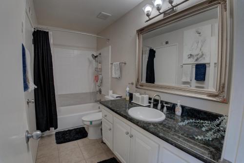 een badkamer met een wastafel, een toilet en een spiegel bij 2 story Casual Cute Condo 6 miles from Disneyland & 8 miles Knotts 2bd 2bth Sleeps 8 plus in Cypress