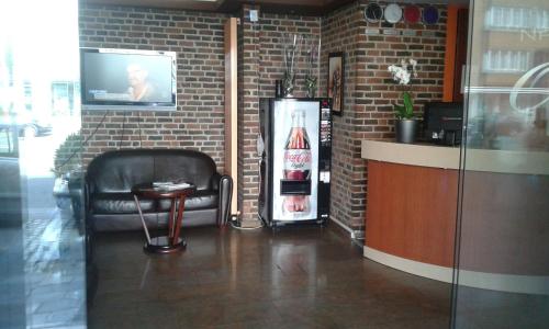 - un bar avec machine à soda et télévision sur un mur en briques dans l'établissement Hotel Prince de Liege, à Bruxelles