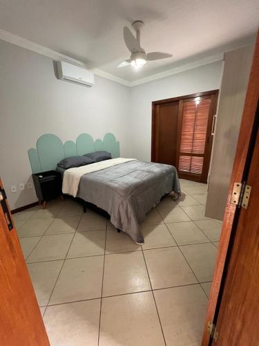 a bedroom with a bed with blue chairs in it at Casapark2indaiatuba in Indaiatuba