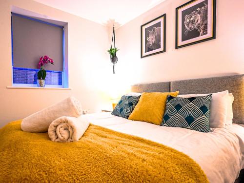 a bedroom with a large bed with a yellow blanket at Golden King Suite - Balcony & FREE Parking - Central Bedford in Bedford