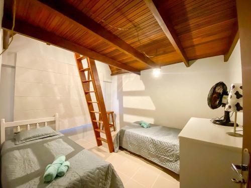 1 dormitorio con 2 camas individuales y escalera en Apartamento Cobertura Guaratuba, en Guaratuba
