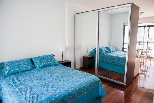 ein Schlafzimmer mit einem Bett und einem großen Spiegel in der Unterkunft Cabello trendy in Buenos Aires