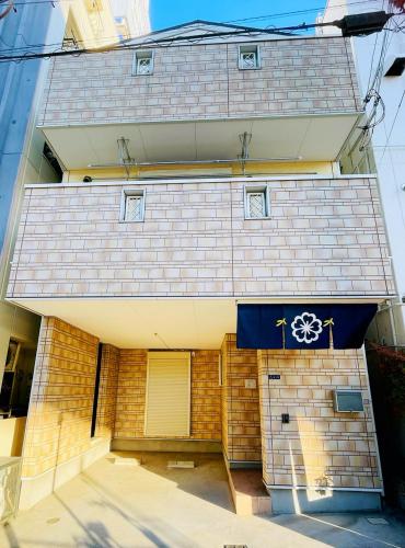 a brick building with a door with a wheel on it at 無料駐車場 3階建て一軒家 最大10人 3寝室 2トイレ ペットOK家族団体向き Usj 道頓堀 難波近い 民泊花園西 in Osaka