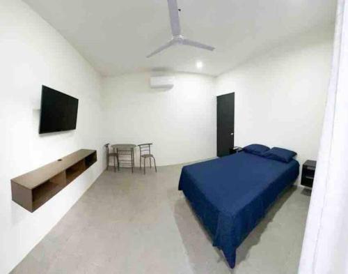 a bedroom with a blue bed in a white room at Habitación privada en Huatulco in Santa Cruz Huatulco