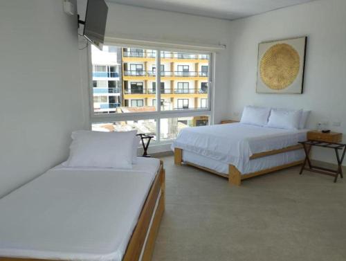 1 dormitorio con 2 camas y ventana grande en Santa Julia Travel, en San Andrés