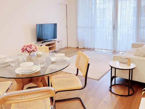 a living room with a table and chairs and a television at Mascot Cozy Apartment + Free Parking in Sydney