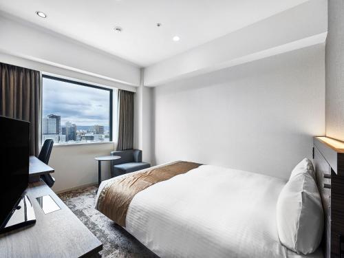 a hotel room with a bed and a window at DEL style Osaka-Shinsaibashi by Daiwa Roynet Hotel in Osaka