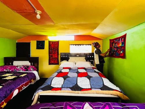 um homem de pé num quarto com duas camas em Urosfood & Titiqaqa Lodge em Uros