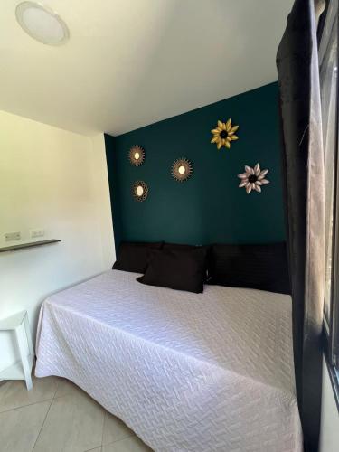 ein Schlafzimmer mit einem Bett mit Blumen an der Wand in der Unterkunft APARTAMENTO AMOBLADO, LISTO PARA ESTRENAR. in Bello