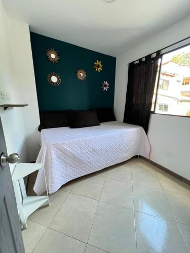 una camera con un letto con una parete verde di APARTAMENTO AMOBLADO, LISTO PARA ESTRENAR. a Bello