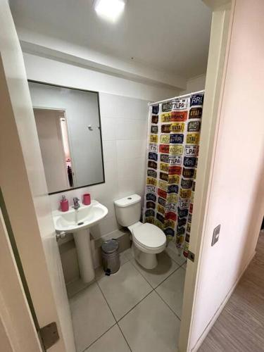 a bathroom with a toilet and a sink and a mirror at Arriendo departamento Amunategui in Iquique