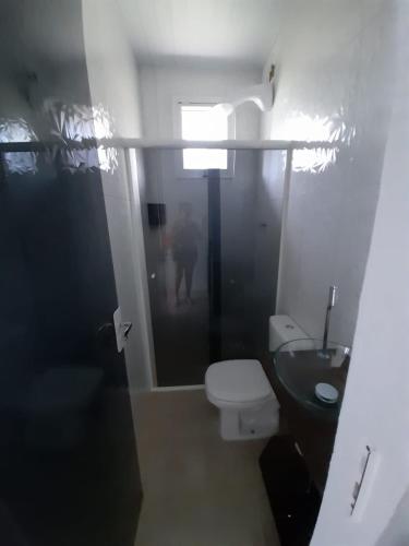 a bathroom with a toilet and a sink at Mini Casa Chácara Zulin's - AMOR E ACONCHEGO in Pontal do Paraná
