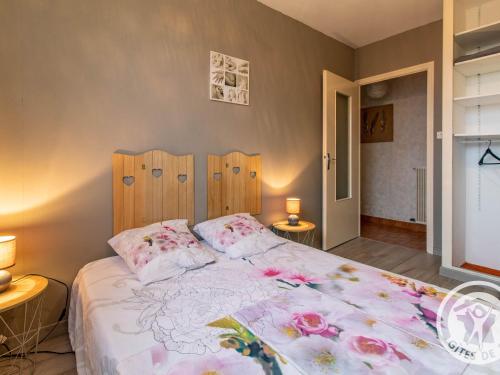 Un dormitorio con una cama grande con flores. en Gîte Chemillé-en-Anjou-Chemillé-Melay, 4 pièces, 6 personnes - FR-1-622-11 en Saint-Georges-du-Puy-de-la-Garde