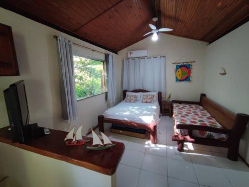 um quarto com uma cama e uma mesa com sapatos no chão em Chalé da Barra - Loft em Maraú