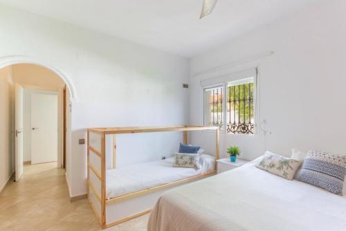 1 dormitorio blanco con 2 camas y ventana en ETELVILLA, en El Puerto de Santa María