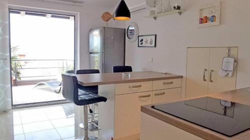 uma cozinha com um frigorífico de aço inoxidável e um balcão em Apartments with a parking space Njivice, Krk - 21767 em Njivice