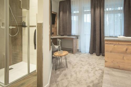 a kitchen with a shower and a table in a room at Hotel dasZimmermann in Todtmoos