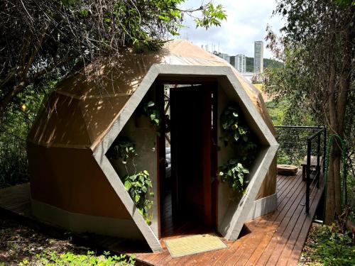 a dome house with a door on a deck at Domo Vila da Serra in Nova Lima