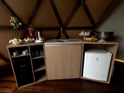 a small kitchen with a counter and a trash can at Domo Vila da Serra in Nova Lima