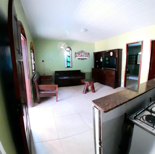 eine Küche und ein Wohnzimmer mit einem Sofa und einem Tisch in der Unterkunft casa do serramar in Rio das Ostras