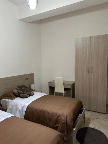 a bedroom with two beds and a table and a desk at B&B Rosario in Gioia Tauro