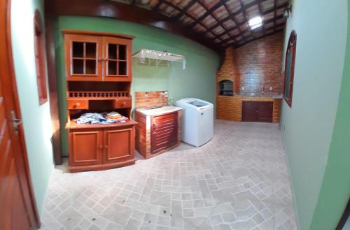 a large kitchen with green walls and a refrigerator at casa do serramar in Rio das Ostras