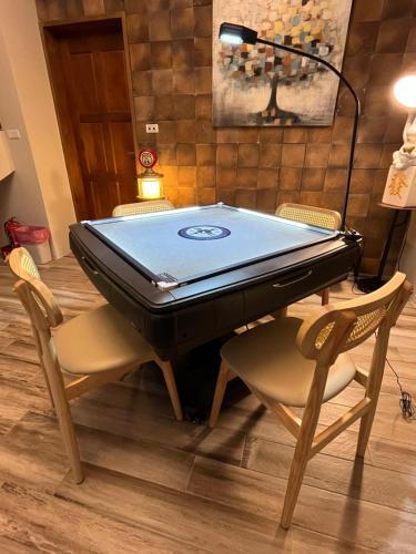 a ping pong table with two chairs and a laptop on it at Annong Image Vacation Home in Sanxing