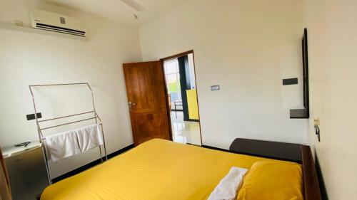1 dormitorio con 1 cama amarilla en una habitación en villa24.trinco en Trincomalee
