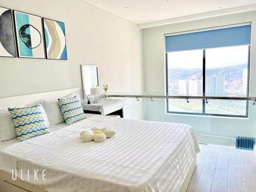 a bedroom with a white bed with two stuffed animals on it at YLY HOUSE in Ha Long