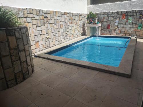 a large swimming pool in a brick wall with at Hotel Pousada Farol de Manaíra in João Pessoa