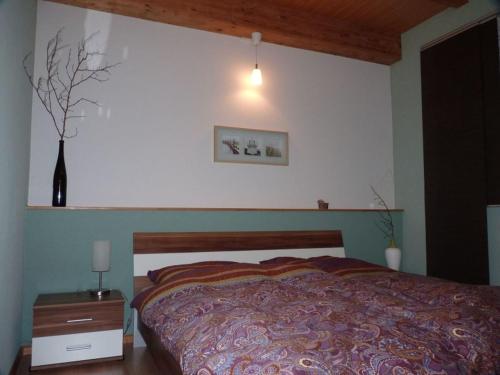 1 dormitorio con 1 cama y un jarrón en la pared en Haus zur Eule en Todtnau