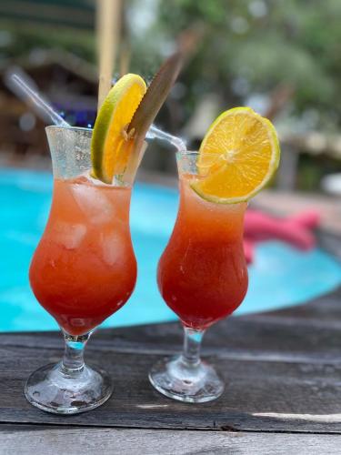 two cocktails sitting on top of a wooden table at Chalés da Cris in Fortim