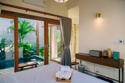 a bedroom with a bed and a large window at Mamori House at Kohlarn in Ko Larn