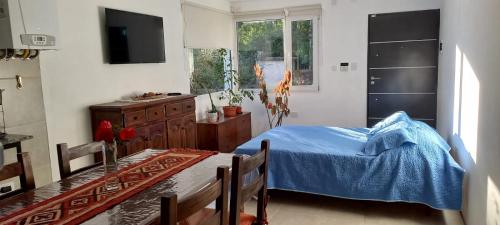 1 dormitorio con cama, mesa y TV en CASITA DE ANELÉ en San Carlos de Bariloche