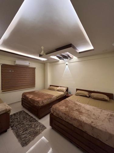 a bedroom with two beds and a ceiling at AL-MANAL 305 Premium Room 5 beds in Bhatkal