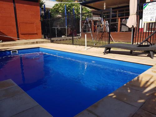 uma piscina azul com um banco ao lado de um edifício em Spacious self contained unit - short walk to Grange Jetty em Grange