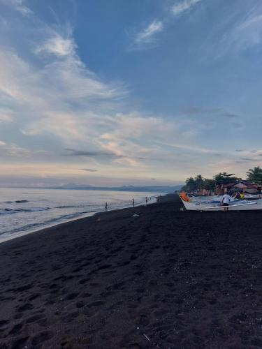- un bateau assis sur une plage au bord de l'océan dans l'établissement Kua's Pad Batangas Tent, à Calatagan