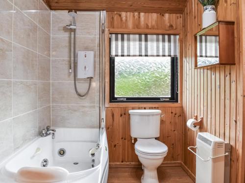 y baño con bañera, aseo y lavamanos. en Glendowlin Lodge Retreat en Tirril