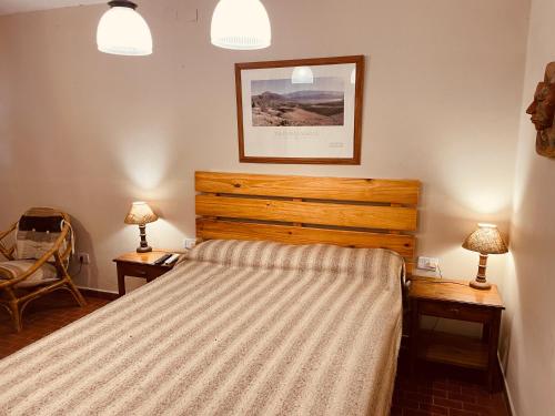 1 dormitorio con 1 cama con 2 mesas y 2 lámparas en Departamento en el centro Tafi del Valle en Tafí del Valle