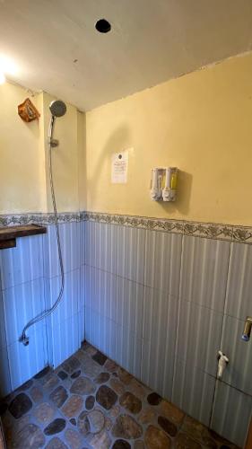 łazienka z prysznicem z niebieskimi i szarymi płytkami w obiekcie BIG K HOSTEL w mieście Karimunjawa