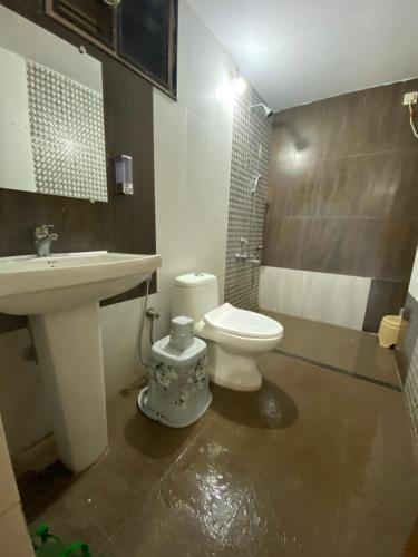 a bathroom with a white toilet and a sink at AL-MANAL 304 premium Room 5Beds in Bhatkal