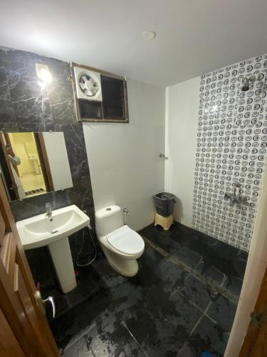 a bathroom with a toilet and a sink at AL-MANAL 306 Premium Room Triple Bed in Bhatkal