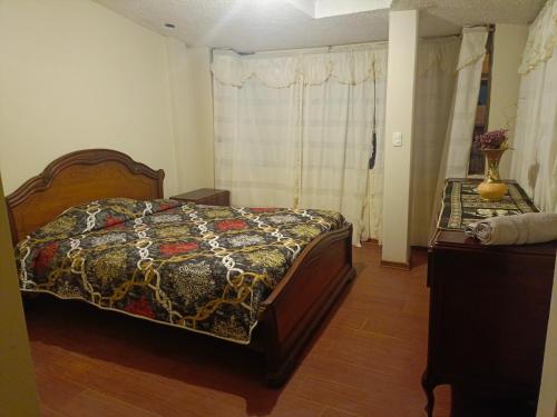 1 dormitorio con 1 cama con edredón en Acogedor apartamento en Píllaro, en Píllaro