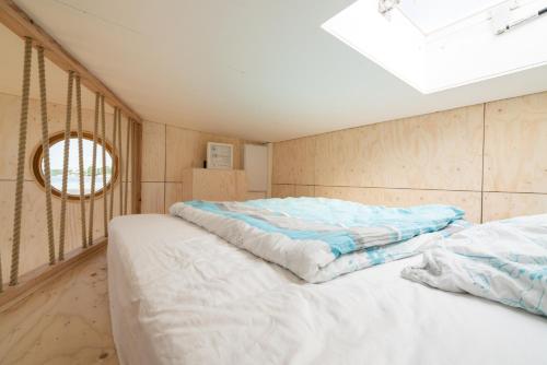 a bedroom with two beds and a skylight at Hausboot Helena in Schleswig