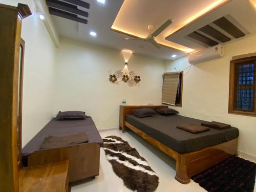 a bedroom with two beds and a ceiling at AL-MANAL 306 Premium Room Triple Bed in Bhatkal